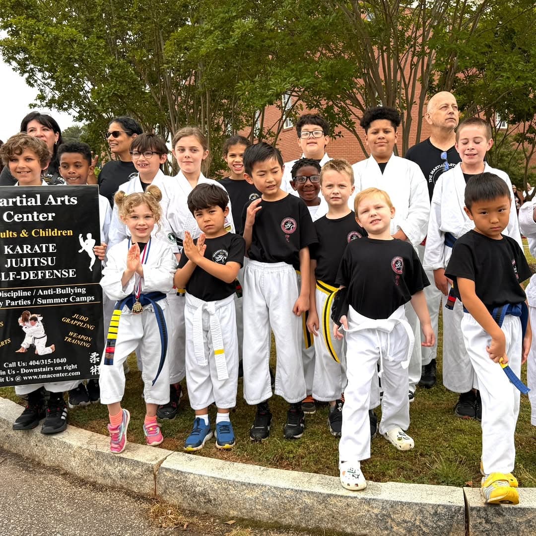 Students and instructors outside next to The Martial Arts Center sign